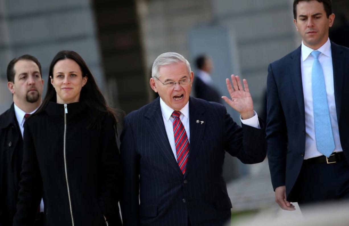 Sen. Robert Menendez, D-N.J., second right, exits federal court in Newark, N.J., in November. A federal judge dismissed bribery charges against the senator Wednesday.