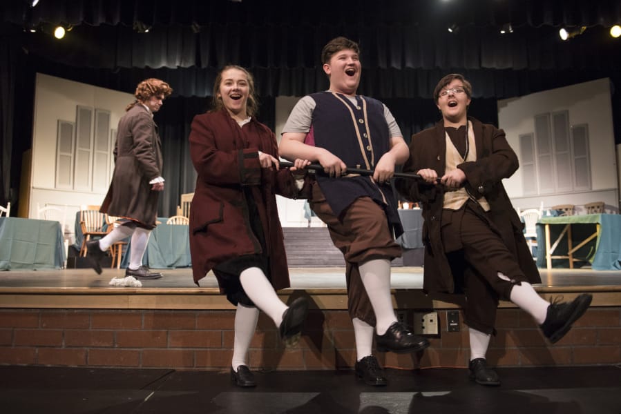 A colonial chorus line: Heritage High School junior Dakota Adams, left, senior Jordyn Fields, and sophomore Connor Randall step-kick their way to American independence in the musical “1776.” Alisha Jucevic/The Columbian