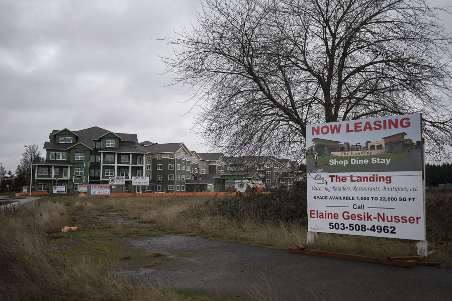 Springwood Landing, left, is seen under construction as a sign advertises space at a nearby commercial development. Springwood Landing is 80 percent pre-leased and won’t open for at least four months.