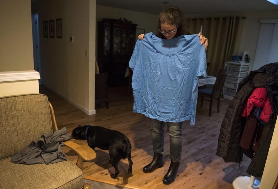 Meghan Green holds up one of her old shirts on Tuesday afternoon in her Ridgefield home.