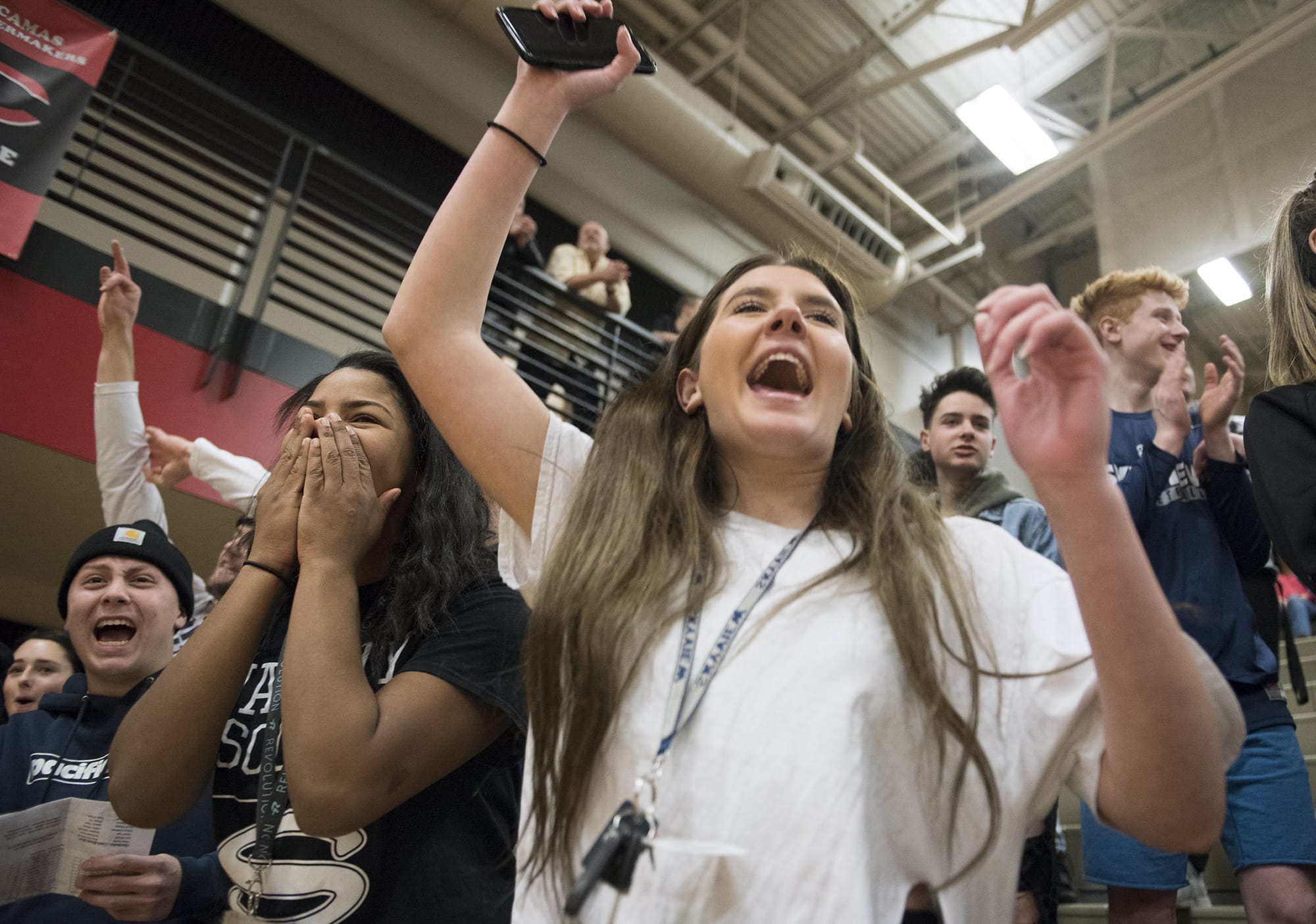 Skyview senior Evan Aguilar, left, sophomore Mikelle Anthony, center, and junior Kayla Rakoz, right, cheer on their team during the 4A GSHL opener against Camas Wednesday night, Jan. 3, 2018 at Camas High School.