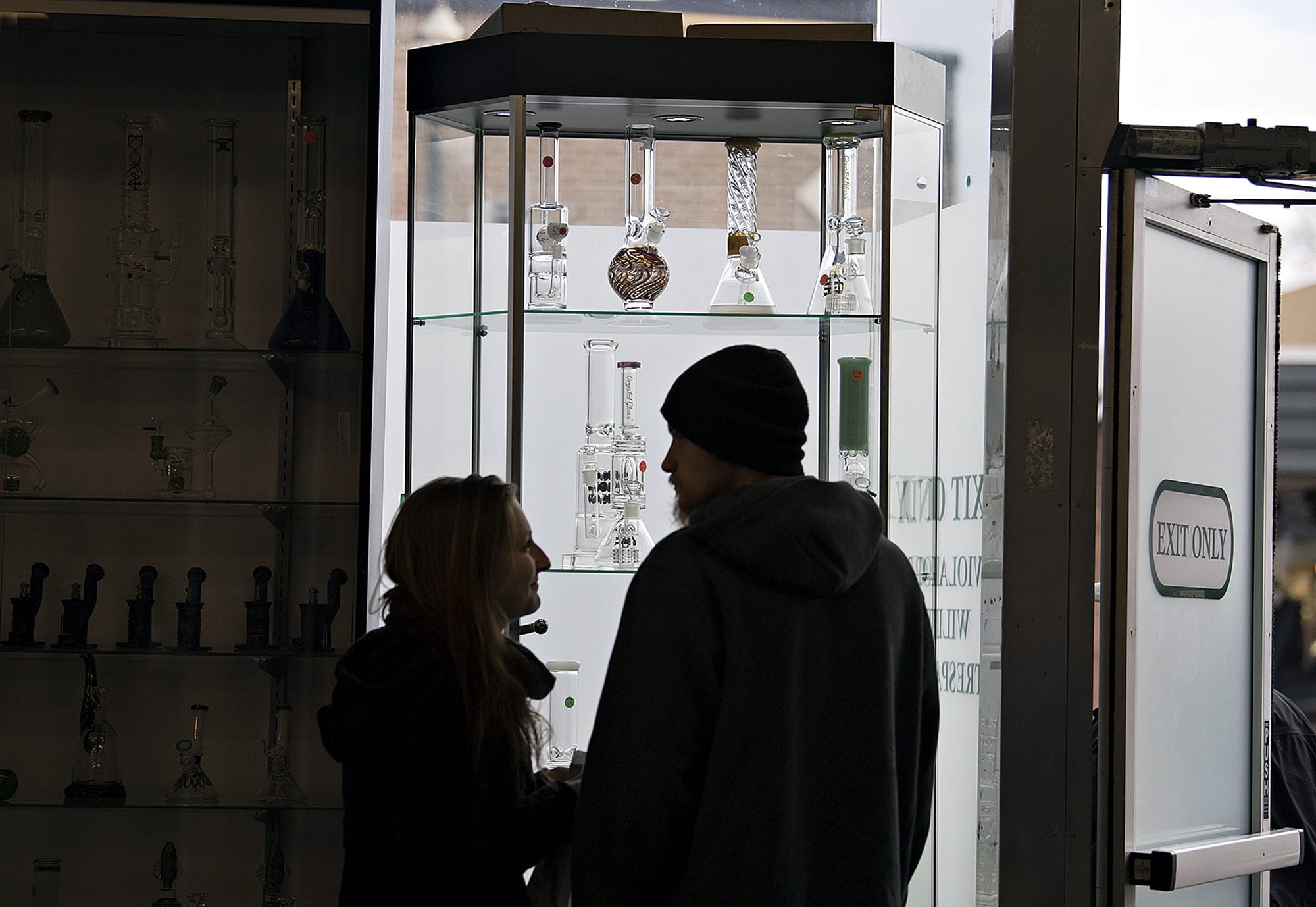 Samantha Rosaaen of Oregon City, left, looks over the selection of marijuana-related products at Main Street Marijuana with her boyfriend, Tanner Barnett, on Thursday morning. The federal government is talking about rolling back protections for states selling marijuana, such as Washington.
