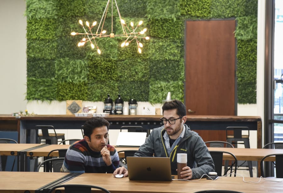 Amey Laud, left, and Josh Iwata, employees of ClassHero, work together at CoLab, a shared office space in Vancouver. CoLab purchased competitor Columbia Collective and officially took over the space Jan. 1.