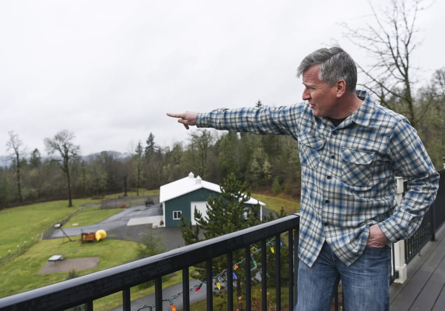 Sean Streeter points toward a gravel pit across Gibbons Creek that he says has disturbed the peace and quiet his family has enjoyed living outside of Washougal.