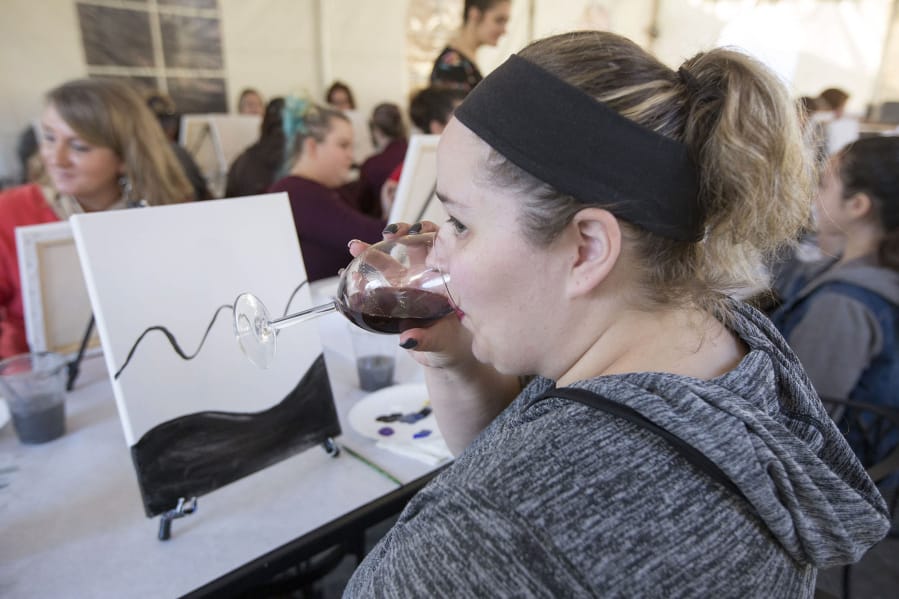 Marci Waldkirch sips a red blend Sunday afternoon between filling in the early touches of what would become the Northern Lights over a mountain range.
