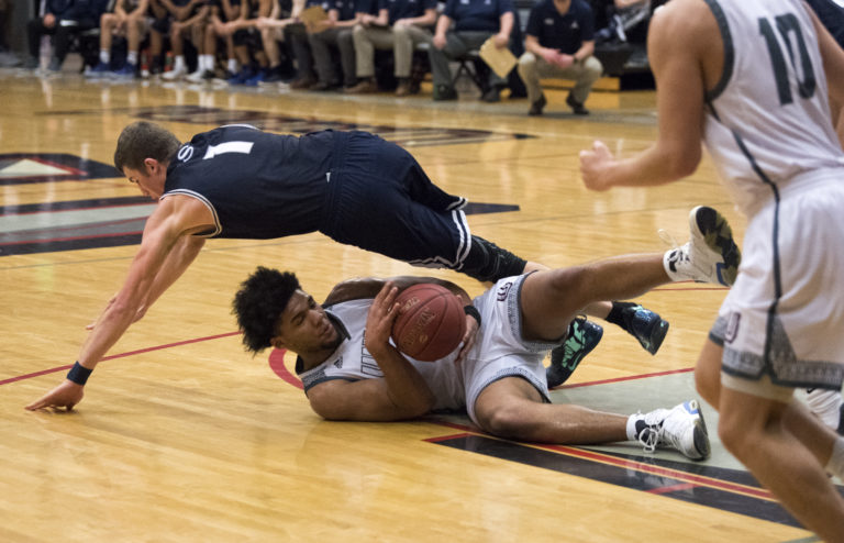 Skyview's Cole Grossman (1) falls over Union's Alishawuan Taylor (22) as they scramble for the ball during Tuesday night's game at Union High School on Jan. 23, 2018.