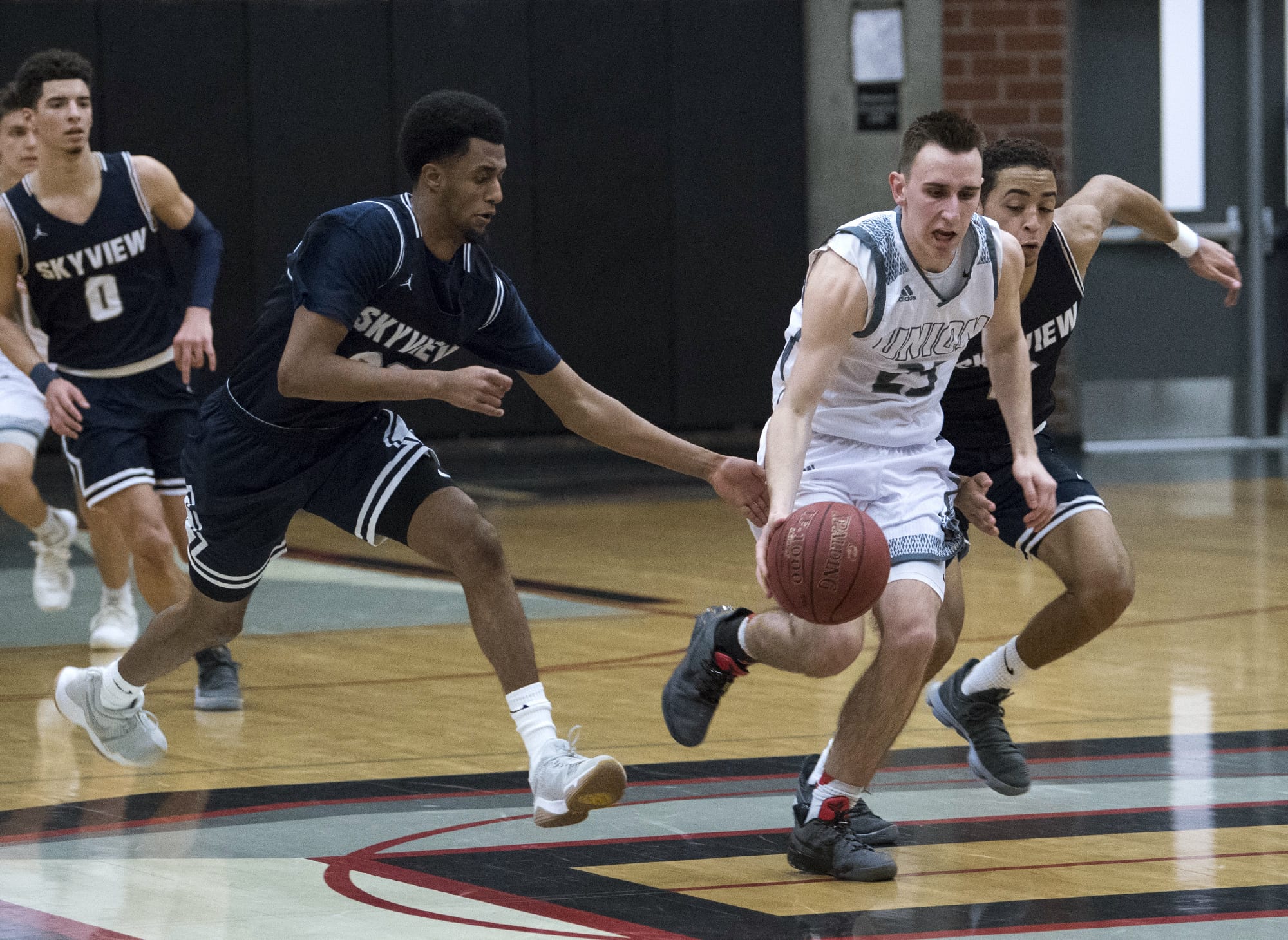 Skyview's KB Fesehazion (22) and Jovon Sewelll (2) sprint after Union's Ethan Smith as he dribbles down court with second left in Tuesday night's game at Union High School on Jan. 23, 2018.