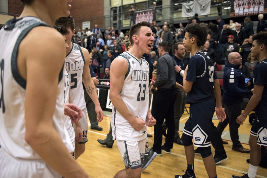 Union's Ethan Smith (23) celebrates Tuesday night's win against Skyview at Union High School on Jan. 23, 2018. The Titans won 72-69.
