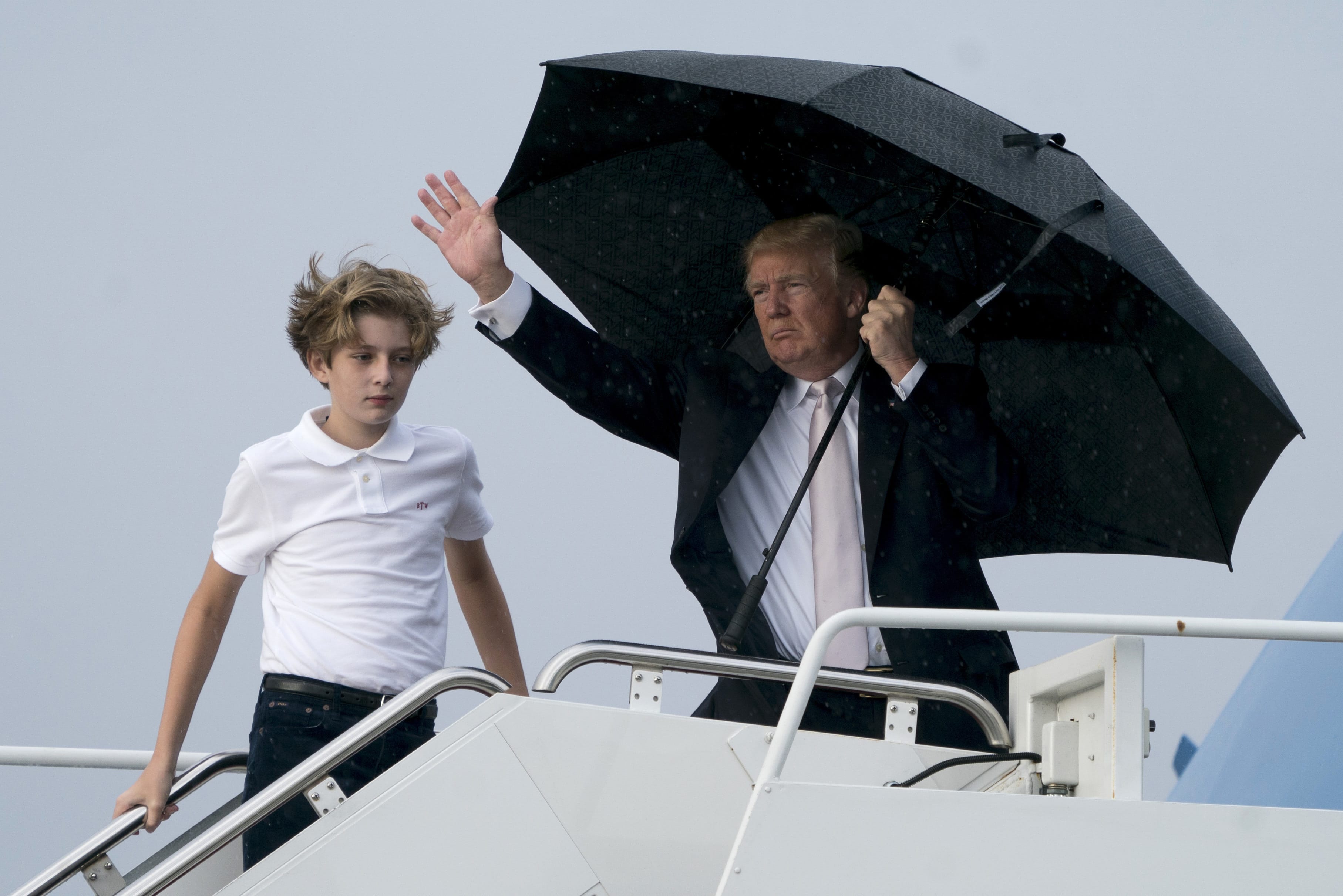 President Donald Trump and his son Barron board Air Force One at Palm Beach International Airport in West Palm Beach, Fla., Monday, Jan. 15, 2018, to travel to Washington. President Trump spent the holiday weekend at Mar-a-Lago, his club in Palm Beach, Fla.