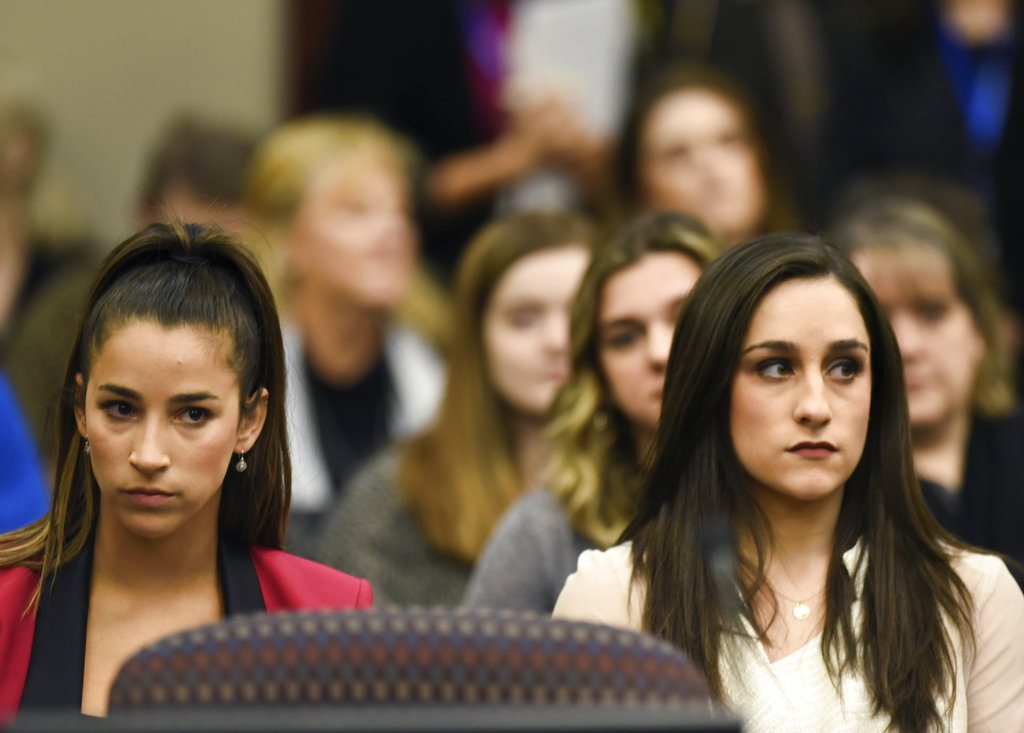 Former Olympians Aly Raisman, left, and Jordyn Wieber sit in Circuit Judge Rosemarie Aquilina's courtroom during the fourth day of sentencing for former sports doctor Larry Nassar, who pled guilty to multiple counts of sexual assault, Friday, Jan. 19, 2018, in Lansing, Mich.