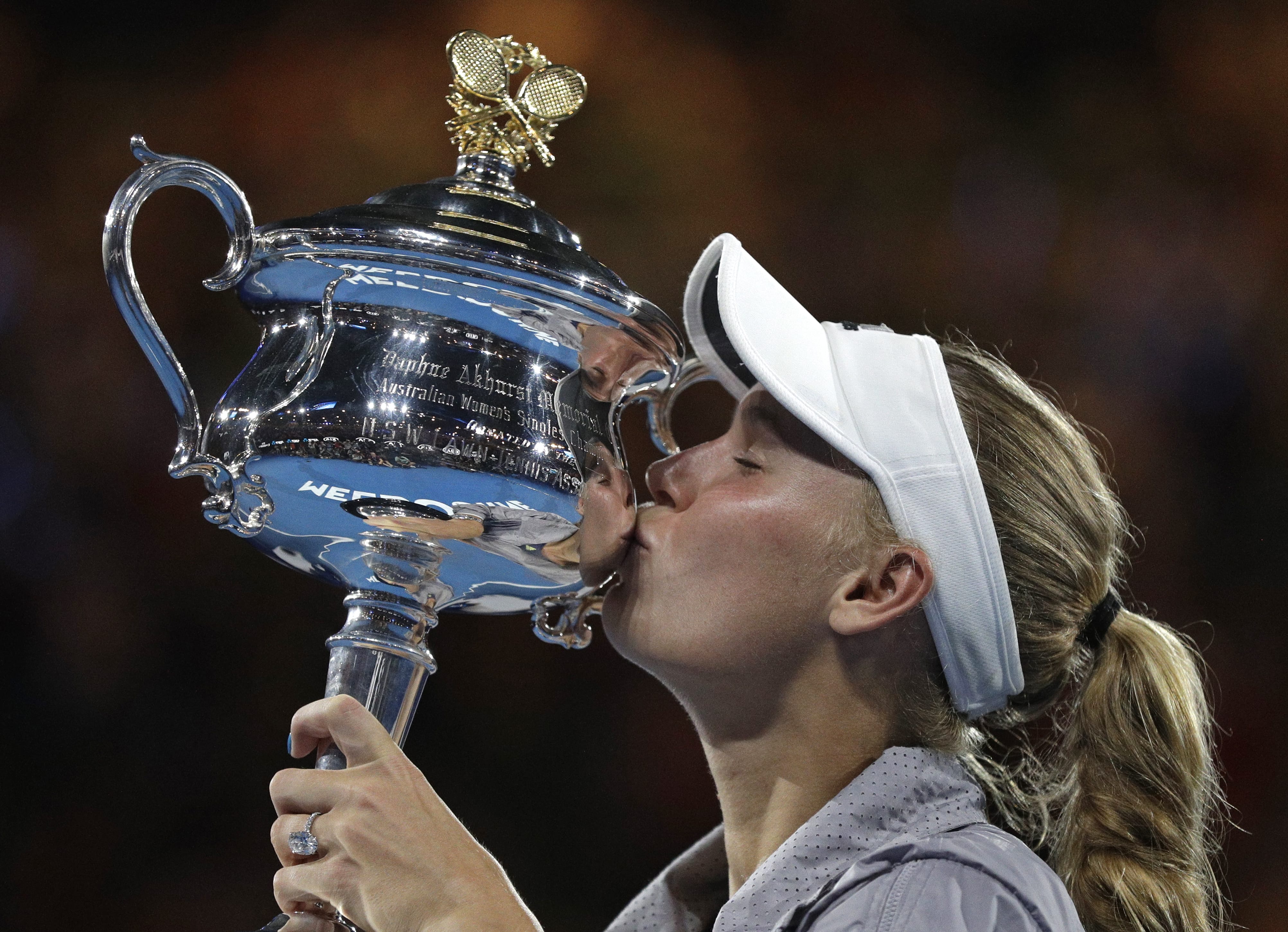 Denmark's Caroline Wozniacki kisses her trophy after defeating Romania's Simona Halep during the women's singles final at the Australian Open tennis championships in Melbourne, Australia, Saturday, Jan. 27, 2018.