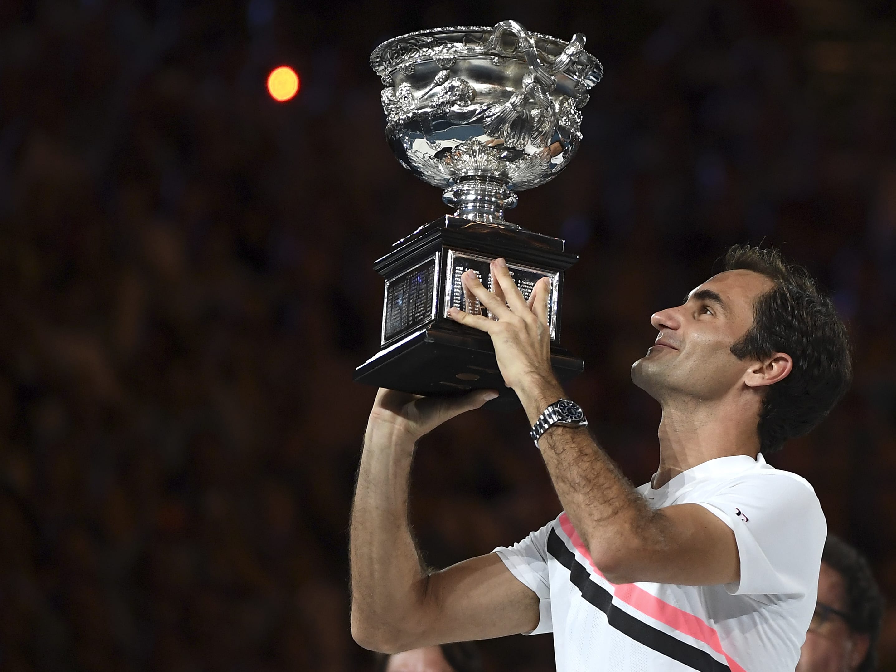 Switzerland's Roger Federer holds his trophy aloft after defeating Croatia's Marin Cilic during the men's singles final at the Australian Open tennis championships in Melbourne, Australia, Sunday, Jan. 28, 2018.