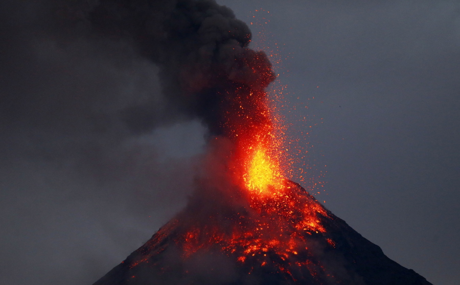 Mayon volcano spews red-hot lava in another eruption as seen from Legazpi city, Albay province, roughly 200 miles (340 kilometers) southeast of Manila, Philippines, Tuesday, Jan. 23, 2018. Mayon has spewed fountains of red-hot lava and massive ash plumes anew in a dazzling but increasingly dangerous eruption that has sent 56,000 villagers fleeing to evacuation centers.