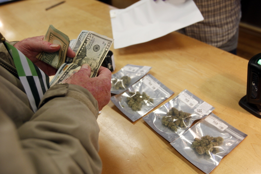FILE - In this Monday, Jan. 1, 2018 file photo, a customer purchases marijuana at the Harborside marijuana dispensary in Oakland, Calif., on the first day that recreational marijuana was sold legally in California. In January 2018, Attorney General Jeff Sessions rescinded a 2013 Obama Administration policy pledging that federal authorities would not crack down on marijuana operations in states where they were legal as long as the states maintained tight regulations.