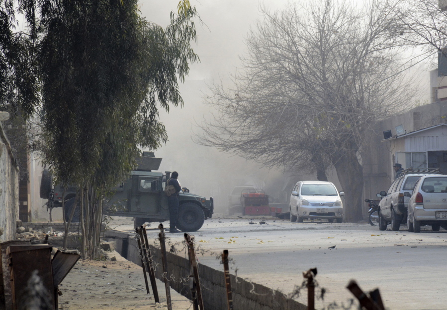 Afghan security personnel stand guard at the scene of a deadly suicide attack in Jalalabad, east of Kabul, Afghanistan, on Wednesday. Attahullah Khogyani, spokesman for the provincial governor said a group of gunmen stormed the office of the non-governmental organization, Save the Children.