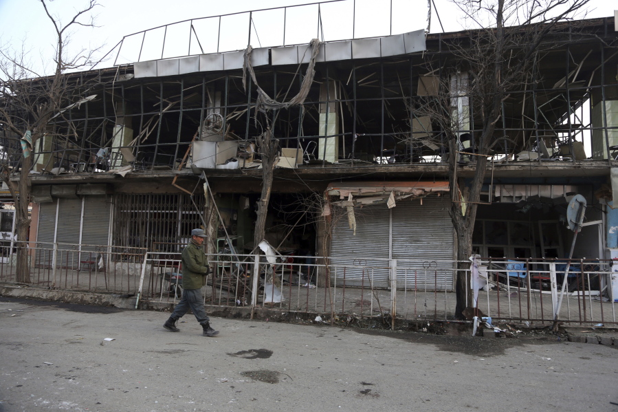 A member of Afghan security forces walks past the site of Saturday’s suicide attack in Kabul, Afghanistan, on Sunday. President Donald Trump is condemning “the despicable car bombing attack” in the Afghan capital of Kabul.