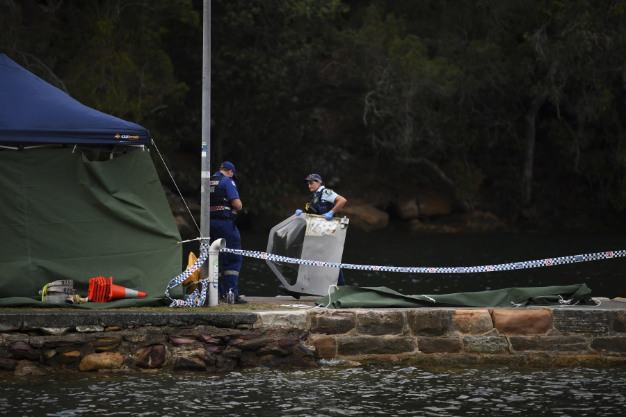 Emergency workers carry to shore what is believed to be debris from a seaplane that crashed into the Hawkesbury River, north of Sydney, Australia, on New Year’s Eve. The crash killed six people.