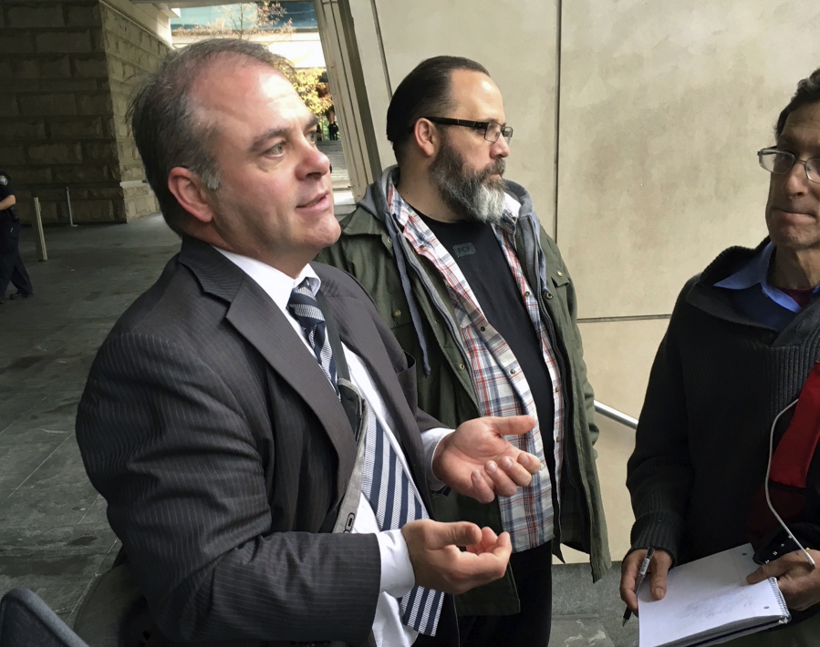 FILE - In this Oct. 26, 2016, file photo, Utah attorney Marcus Mumford, left, stands in front of the federal courthouse in Portland, Ore. Mumford, who represented the leader of an armed occupation of a federal wildlife sanctuary, has agreed to no longer handle federal cases in Oregon.