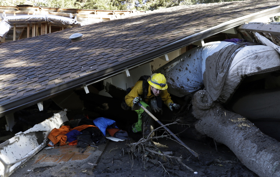 Colette Layton of the Atascadero, Calif., Fire Department, searches a home Saturday in Montecito, Calif. Most residents were under orders to stay out of town as gas and power were expected to be shut off Saturday for repairs.