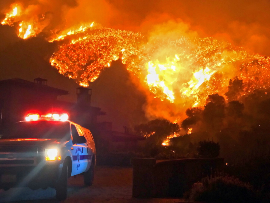 FILE - In this Dec. 12, 2017, file photo provided by the Santa Barbara County Fire Department, fire burns canyons and ridges above Bella Vista Drive near Romero Canyon as the fight to contain a wildfire continues in Montecito, Calif. President Donald Trump has declared a major disaster in California over a wildfire that destroyed more than 1,000 buildings. The White House announced Tuesday, Jan. 2, 2018, that the president has granted disaster status, which will help make federal funds available to supplement recovery efforts in the wake of the Thomas Fire that ravaged Santa Barbara and Ventura counties.