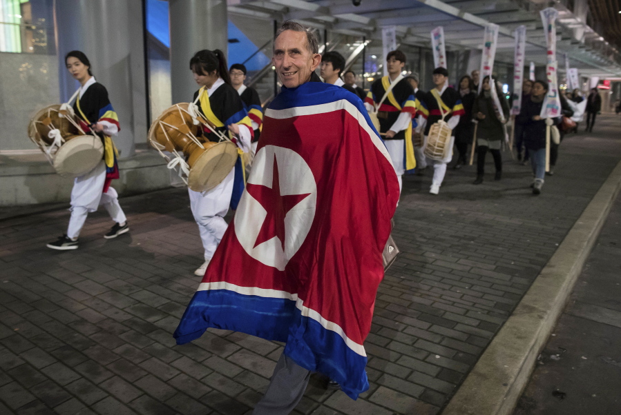 Draped in a North Korean flag, Peter Wilson of New Zealand, marches with protesters outside the site of a summit on North Korea being hosted by Canada and the U.S., in Vancouver, B.C., on Monday. The 20-nation gathering in the west coast Canadian city of Vancouver comes days after a mistaken missile alert caused panic on Hawaii, a stark reminder of the fears of conflict with the North after a year of escalating tension.