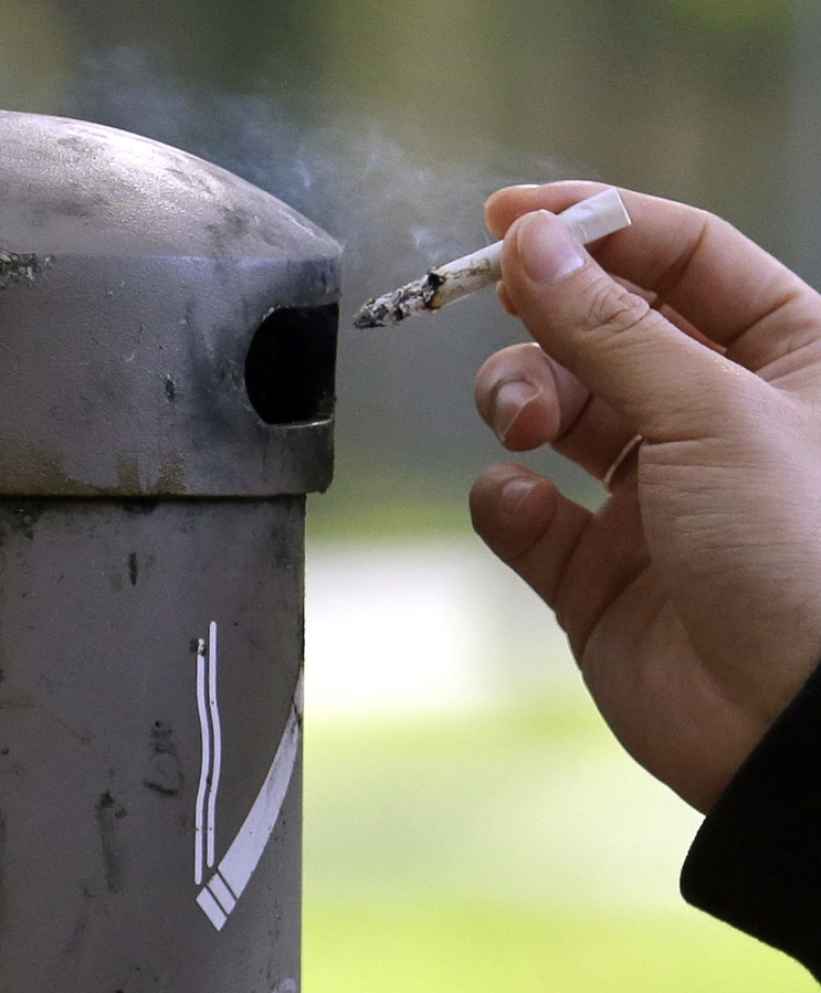 A University of Washington student discards a cigarette into a container at a designated smoking locations on the campus in Seattle. Seventeen public health schools in the U.S. and Canada have pledged to refuse research money from a new anti-smoking group funded by the tobacco industry. Deans of public health schools at Harvard, Johns Hopkins and a dozen other schools said Thursday that the group is too closely tied to an industry that sells harmful products.