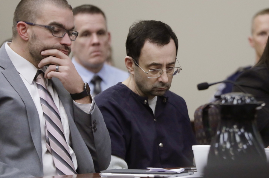 Larry Nassar sits with attorney Matt Newburg during his sentencing hearing Wednesday, Jan. 24, 2018, in Lansing, Mich. The former sports doctor who admitted molesting some of the nation’s top gymnasts for years was sentenced Wednesday to 40 to 175 years in prison as the judge declared: “I just signed your death warrant.” The sentence capped a remarkable seven-day hearing in which scores of Nassar’s victims were able to confront him face to face in the Michigan courtroom.