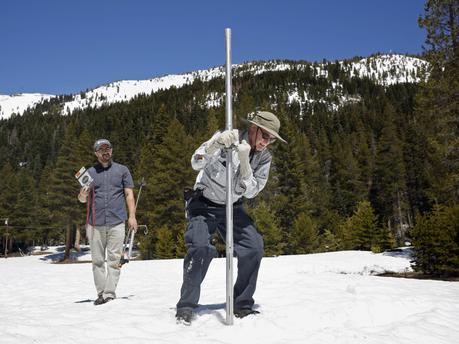 Frank Gehrke, chief of the California Cooperative Snow Surveys Program for the Department of Water Resources, right, plunges the snow survey tube into the snow pack, as DWR’s Wes McCandless looks on during the snow survey at Phillips Station near Echo Summit, Calif. California’s water managers are saying it’s too early yet for fears that the state is sliding back into its historic five-year drought. Water officials carry out the first of their routine seasonal snow surveys in the Sierras on Wednesday, Jan. 3, 2018.
