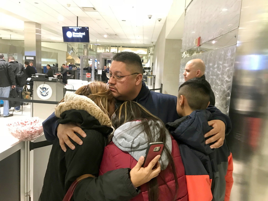 Jorge Garcia hugs his wife, Cindy Garcia, and their two children Monday at Detroit Metro Airport moments before boarding a flight to Mexico. Garcia, who had lived in the U.S. for nearly 30 years, was deported to Mexico.