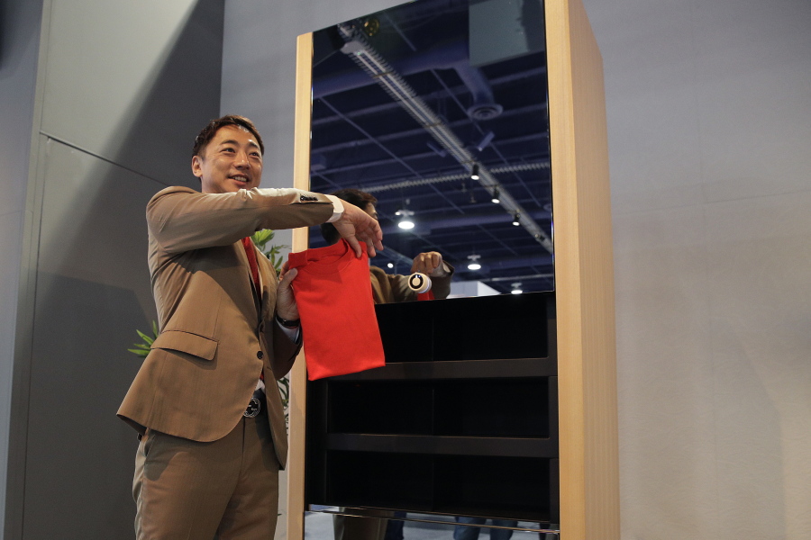 Seven Dreamers CEO Shin Sakane demonstrates use of the Laundroid, a laundry folding machine, at CES International, Wednesday, Jan. 10, 2018, in Las Vegas. (AP Photo/Jae C.