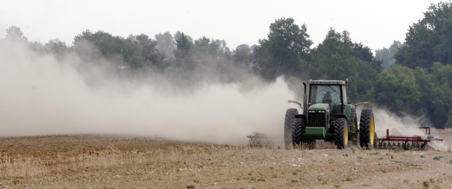 A farm tractor scatters dust as it moves across a field on a farm along state road 82 near Tifton, Ga. Soil is an important natural resource that must be preserved against loss by such forces as wind erosion.