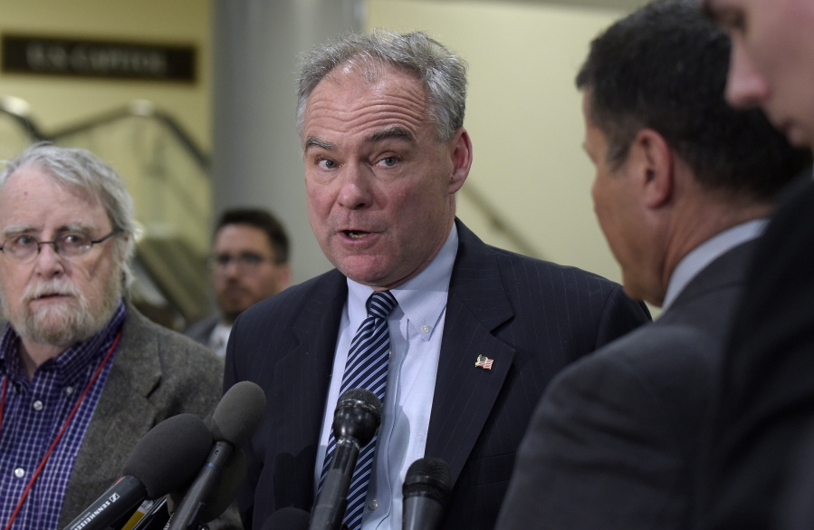 Sen. Tim Kaine, D-Va., center, speaks to reporters on Capitol Hill in Washington. Democrats say they’re shifting to offense on health care, emboldened by successes in defending the Affordable Care Act. They say their ultimate goal is a government guarantee of affordable coverage for all.
