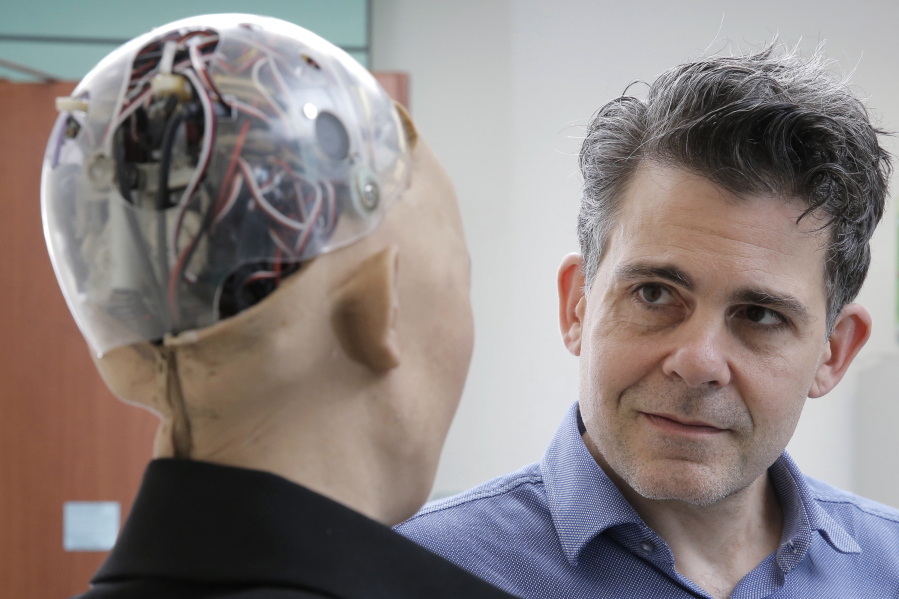 In this Sept. 28, 2017, photo, David Hanson, the founder of Hanson Robotics, talks with his company’s flagship robot Sophia, a lifelike robot powered by artificial intelligence in Hong Kong. Sophia is a creation of the Hong Kong-based startup working on bringing humanoid robots to the marketplace. Hanson envisions a future in which AI-powered robots evolve to become “super-intelligent genius machines” that can help solve mankind’s most challenging problems.