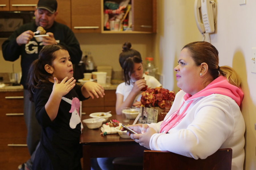 Enghie Melendez sits with her daughters Lidia, left, and Alondra, and husband Fernando Moyet in their hotel kitchen Jan. 9 in the Brooklyn borough of New York. After they lost their home in Puerto Rico to flooding during Hurricane Maria, Melendez fled with her family to the U.S. mainland with three suitcases and the hope that it wouldn’t take long to rebuild their lives.