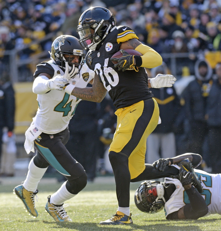 Pittsburgh Steelers running back Le’Veon Bell (26) is tackled by Jacksonville Jaguars free safety Tashaun Gipson, lower right, and strong safety Barry Church, left, during the first half of an NFL divisional football AFC playoff game in Pittsburgh, Sunday, Jan. 14, 2018.