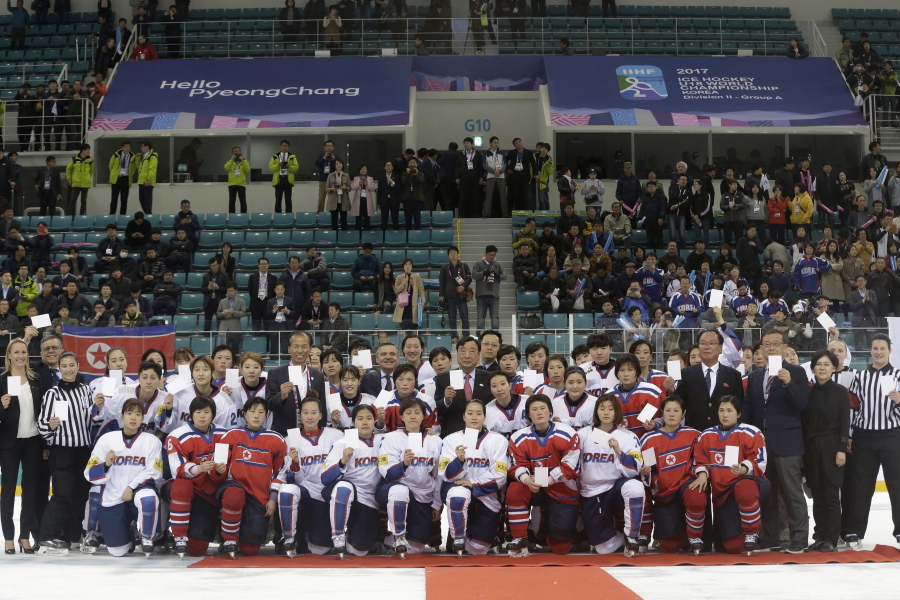 Women’s ice hockey players of South Korea, in white, and North Korea, in red, pose for a photo with International Ice Hockey Federation officials after their Ice Hockey Women’s World Championship Division II Group A game in Gangneung, South Korea. North and South Korea agreed on Monday, Jan. 15, 2018, in principle to field a joint women’s ice hockey team during next month’s Olympics in South Korea, and relayed their position to the International Olympic Committee.