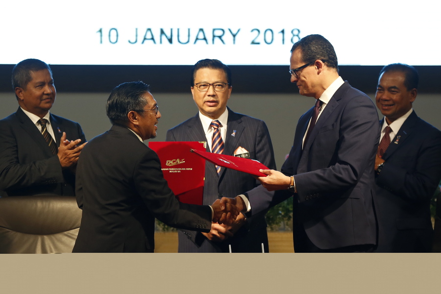 Director General of Civil Aviation Malaysia, Azharuddin Abdul Rahman, left, shakes hand and exchanges the Memorandum of Understanding documents with CEO of Ocean Infinity Limited, Oliver Plunkett, right, during the signing ceremony of the MH370 missing plane search operations between Malaysian government and Ocean Infinity Limited in Putrajaya, Malaysia, on Wednesday.