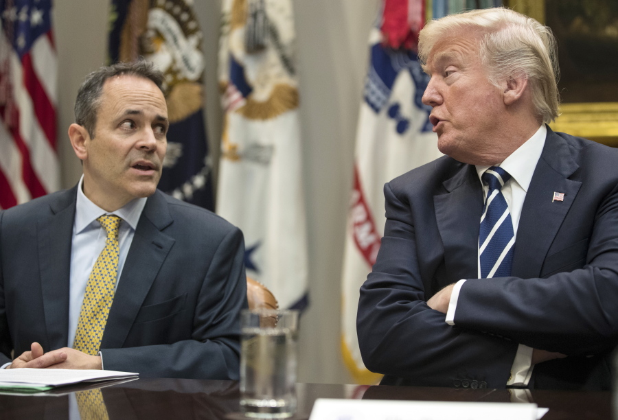 FILE - In this Thursday, Jan. 11, 2018, file photo, President Donald Trump, right, and Kentucky Gov. Matt Bevin, left, talk during a prison reform roundtable in the Roosevelt Room of the Washington. Kentucky has become the first state to win approval from the Trump administration requiring many of its Medicaid recipients to work to receive coverage. The Trump administration gave the go ahead Friday, Jan. 12, 2018.