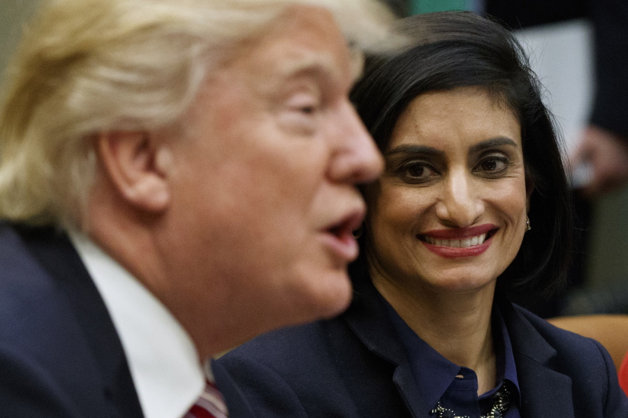 FILE - In this March 22, 2017 file photo, Administrator of the Centers for Medicare and Medicaid Services Seema Verma listen at right as President Donald Trump speaks during a meeting in the Roosevelt Room of the White House in Washington. The Trump administration says it’s offering a path for states that want to seek work requirements for Medicaid recipients, and that’s a major policy shift toward low-income people.