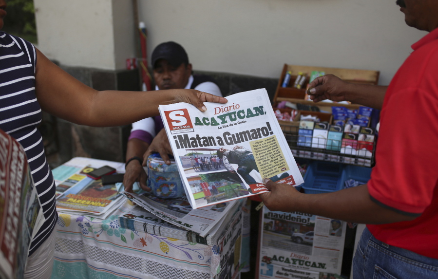 A man buys a newspaper carrying the Spanish headline “They killed Gumaro!” on the sidewalk in Acayucan, Veracruz state, Mexico. For some, Gumaro Perez was an experienced reporter who earned the nickname “the red man” for his coverage of bloody crimes in Acayucan, Veracruz, but in the eyes of prosecutors he was an alleged drug cartel operative who met a grisly end when he was shot dead Dec. 19.