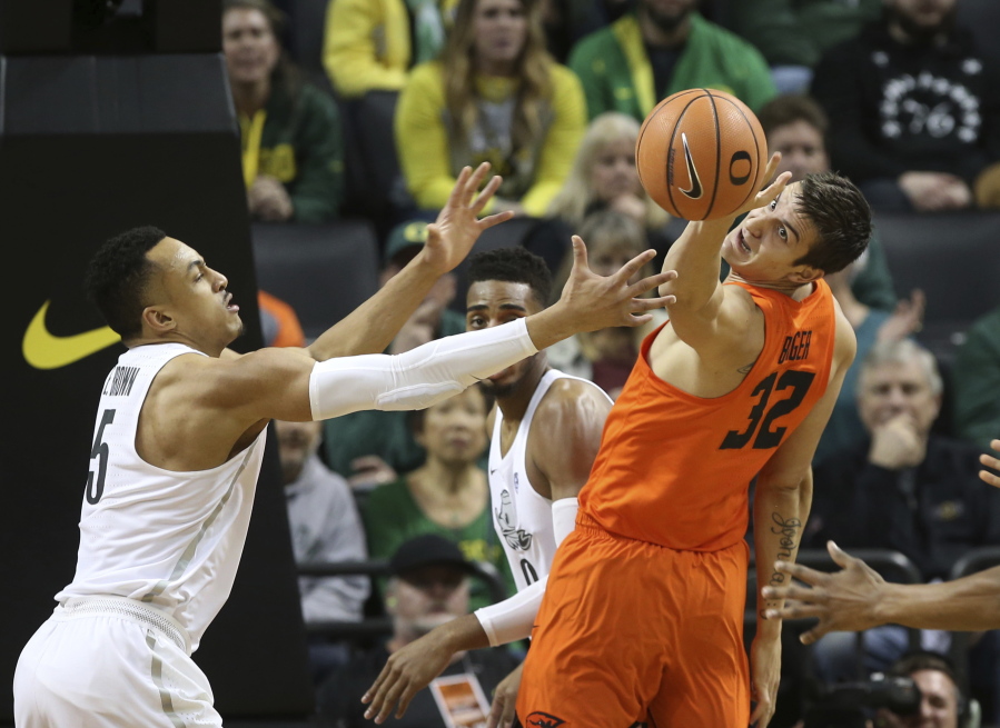 Oregon’s Elijah Brown, left, and Troy Brown Jr., center, battle Oregon State’s Ben Kone for a rebound during the first half of an NCAA college basketball game Saturday, Jan. 27, 2018, in Eugene, Ore.
