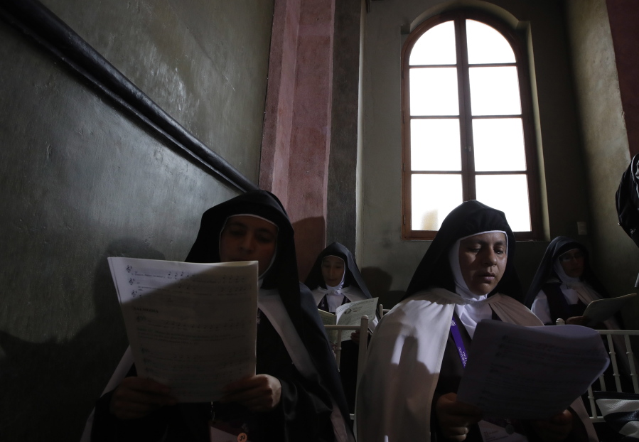 Nuns look at sheet music Sunday as Pope Francis leads mid-morning prayer at the Shrine of Our Lord of the Miracles in Lima, Peru.