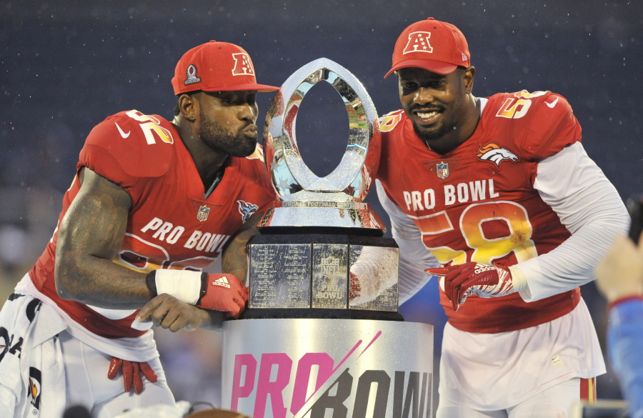 AFC linebacker Von Miller (58), of the Denver Broncos and tight end Delanie Walker (82), of the Tennessee Titans, pose with the NFL Pro Bowl trophy after defeating the AFC 24-23, in Orlando, Fla., Sunday, Jan. 28, 2018.