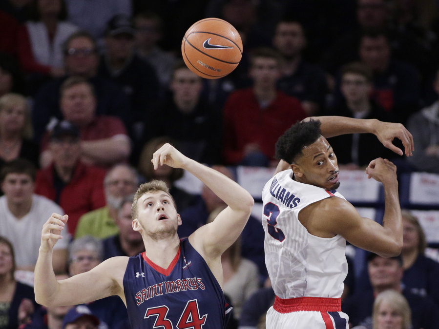Saint Mary’s center Jock Landale (34) and Gonzaga forward Johnathan Williams go after the ball during the first half of an NCAA college basketball game in Spokane, Wash., Thursday, Jan. 18, 2018.