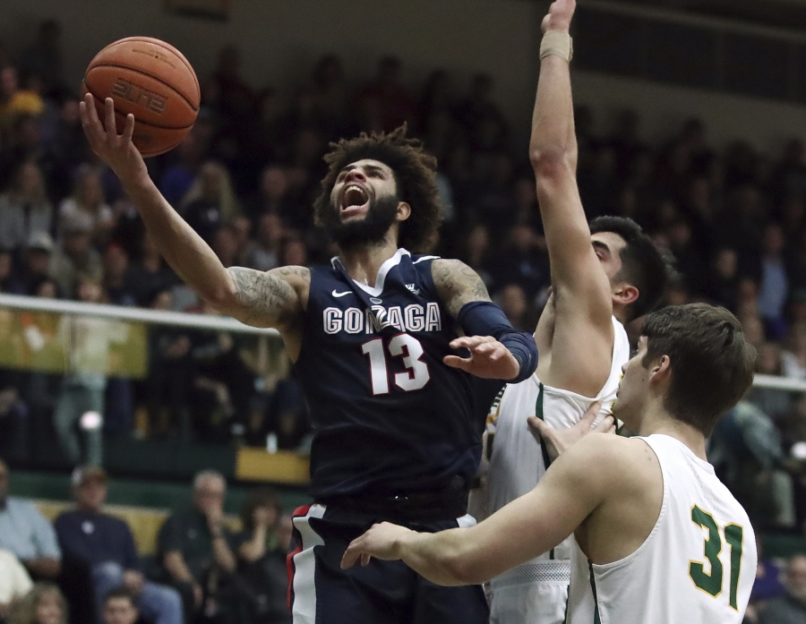 Gonzaga’s Josh Perkins, left, lays up a shot over San Francisco’s Erik Poulsen (31) during the first half of an NCAA college basketball game Saturday, Jan. 13, 2018, in San Francisco.