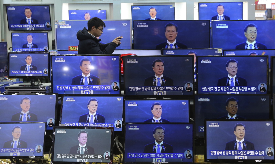A man takes pictures next to TV screens showing the live broadcast of South Korean President Moon Jae-in’s New Year’s speech at the Yongsan Electronic store in Seoul, South Korea, on Wednesday. Moon said he’ll push for more talks and cooperation with North Korea to resolve the nuclear standoff, a day after the two Koreas held high-level talks for the first time in two years and agreed to cooperate in next month’s Winter Olympics in South Korea.
