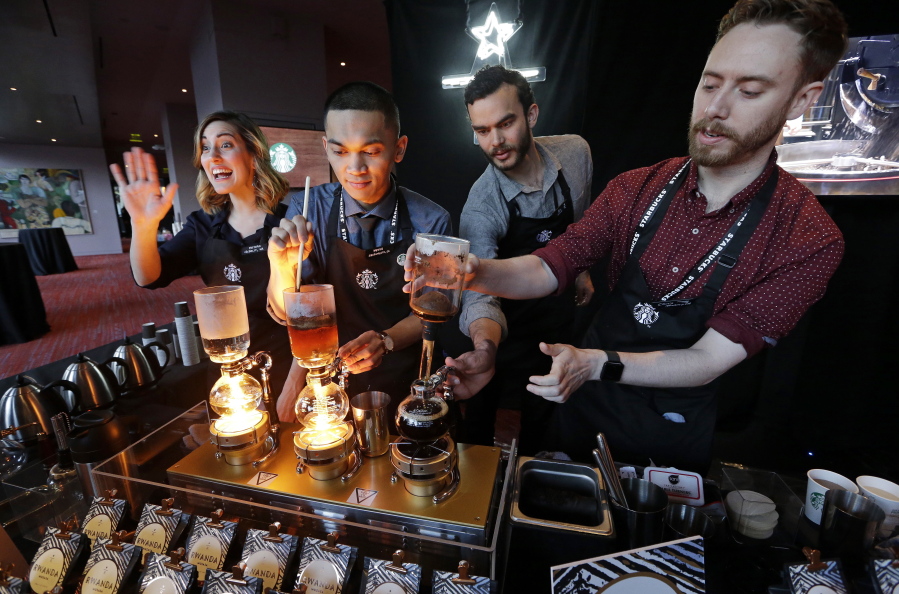 Baristas from Starbucks’ specialized coffee shop, Reserve Roastery, demonstrate a siphon brew of individual cups of coffee in March 2017 before the company’s annual shareholder meeting in Seattle.