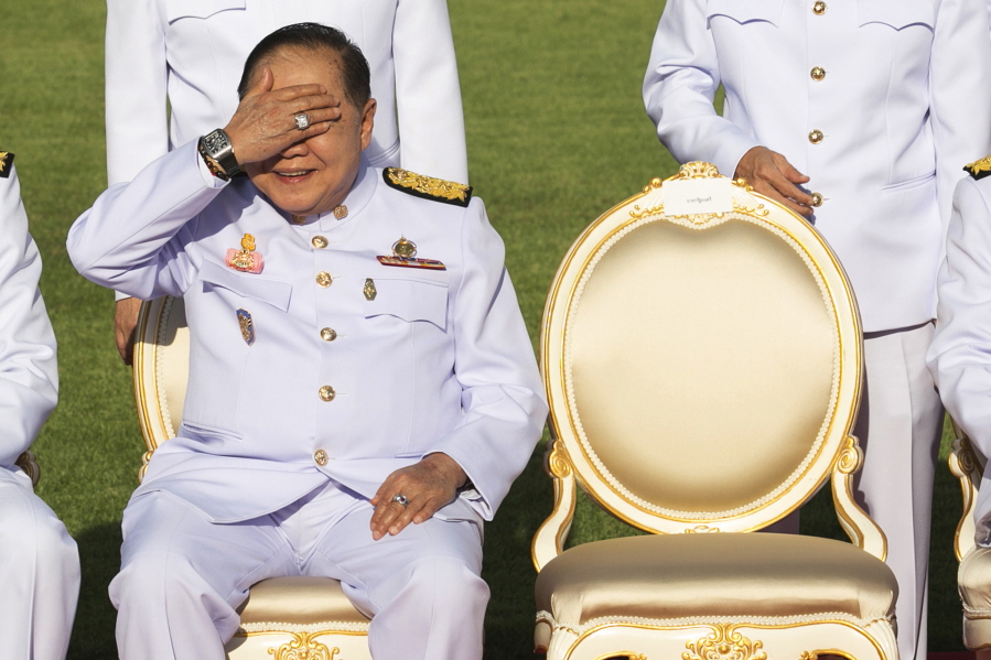 Deputy Prime Minister Prawit Wongsuwan raises his hand to shade the sun wearing a luxury watch and diamond ring Dec. 4 at Government House. Prawit has so far been spotted wearing a total of 25 opulent timepieces, none of which appears on his last declaration of assets.