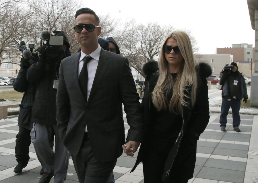 Michael “The Situation” Sorrentino, left, one of the former stars of the “Jersey Shore” reality TV show walks with his fiancee Lauren Pesce while arriving at the Martin Luther King, Jr., Federal Courthouse for a hearing, Friday, Jan. 19, 2018, in Newark, N.J. Sorrentino, who is expected to plead guilty to cheating on his taxes, and his brother, Marc, were charged in 2014 and again last year with multiple counts related to nearly $9 million in income from the show. They had pleaded not guilty, but wrote a letter to the judge this week stating they wanted to change their pleas.