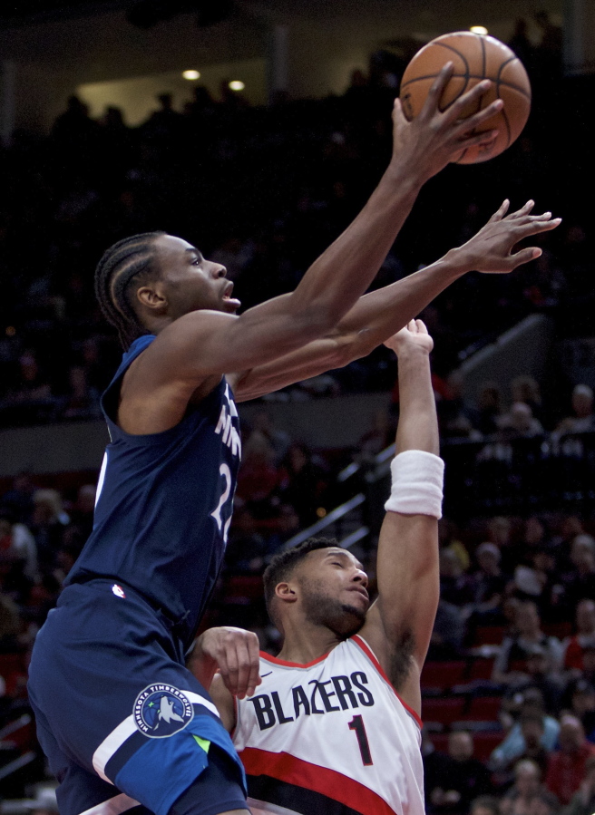 Minnesota Timberwolves forward Andrew Wiggins, left, shoots over Portland Trail Blazers guard Evan Turner during the first half of an NBA basketball game in Portland, Ore., Wednesday, Jan. 24, 2018.